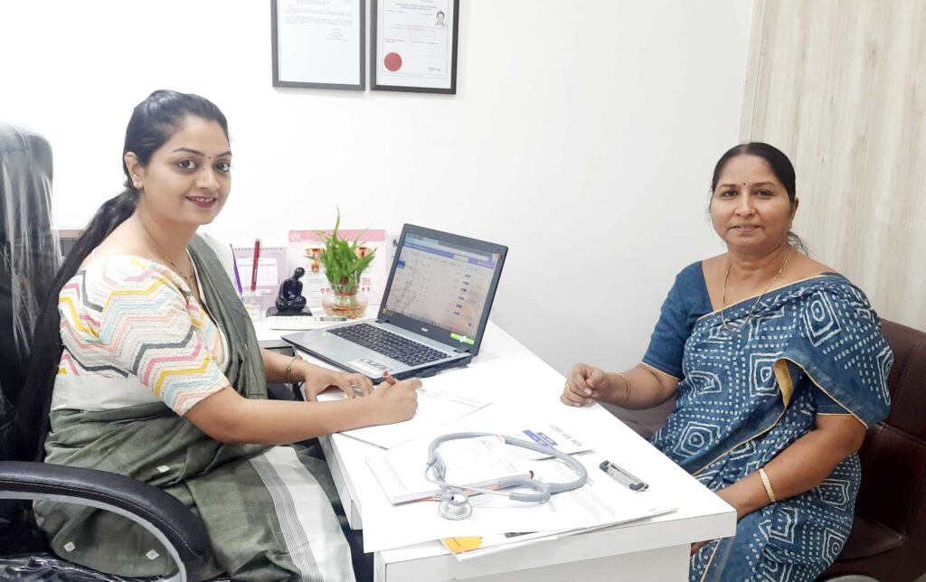 A doctor consults with a woman in a clinic office setting.