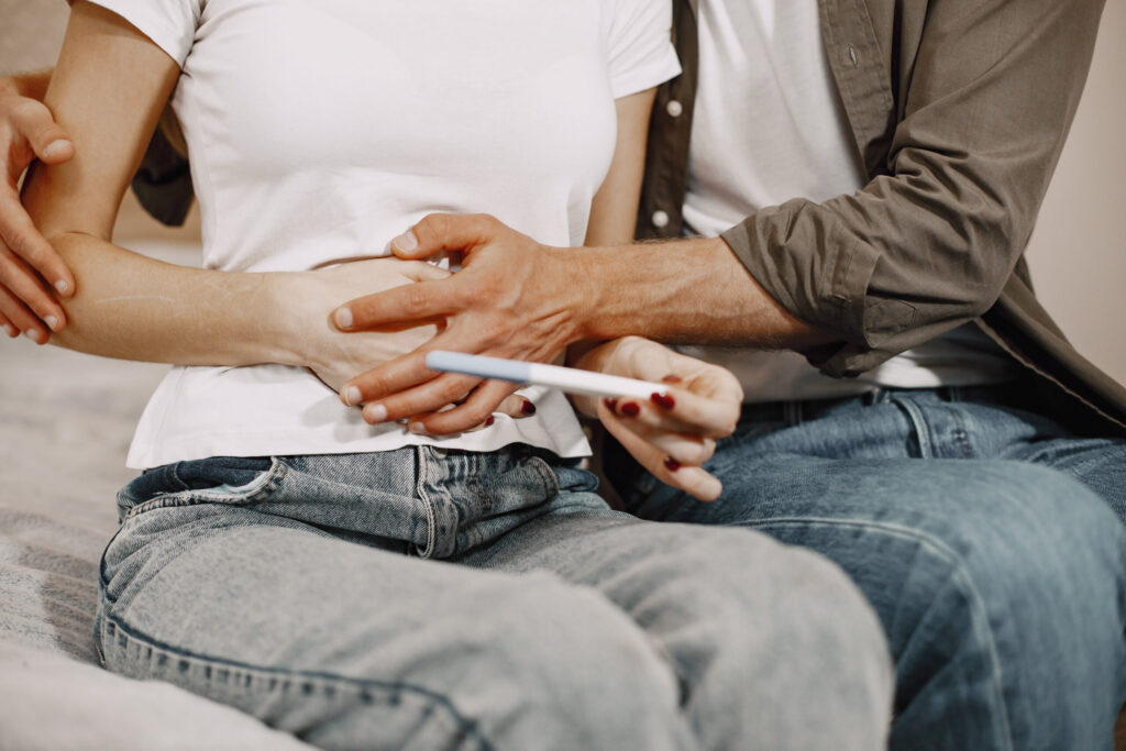 Couple celebrating positive pregnancy news at home after consultation at Eva WomanCare Clinic